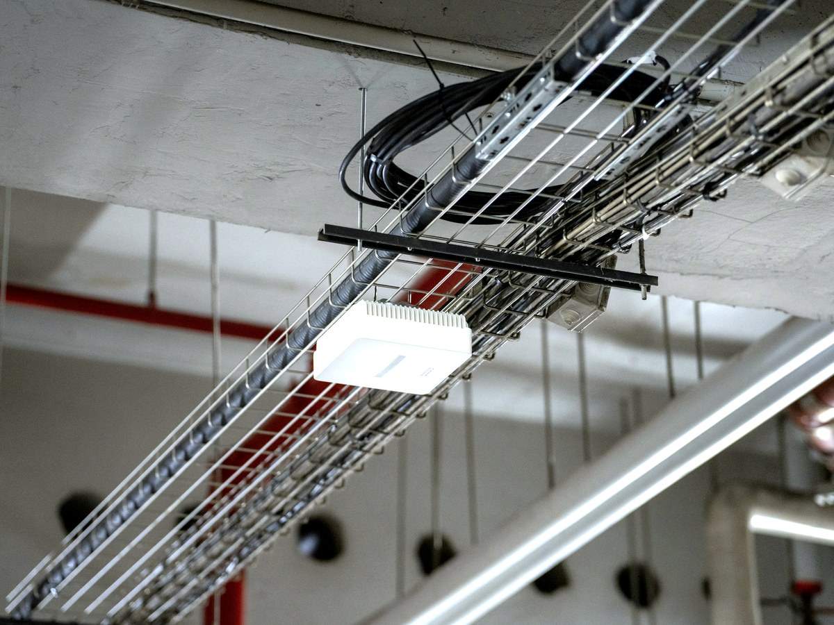 WLAN-Access-Point, montiert auf einer Kabeltrasse in der Zwischendecke